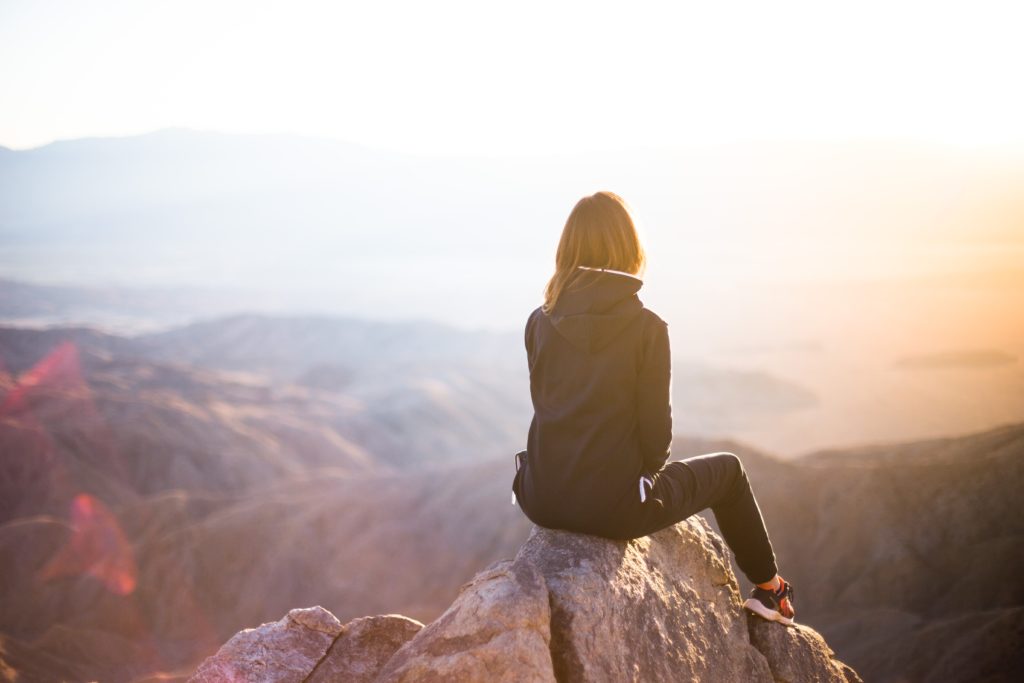 Image of a woman sitting on top of a rock looking at the landscape. As a holistic chiropractor in the Chicago area helping you is more than just giving chiropractic care. In Orland Park, IL I also provide functional medicine and massage therapy. To get start see how we can help speak with our chiropractor in the Chicago area today!