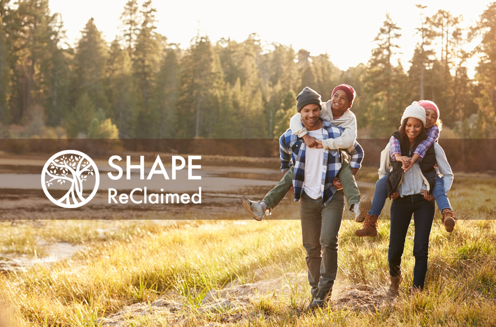 A family of three smiles while walking through a sunny field with the Shape ReClaimed logo. Learn how Shape Reclaimed in the Chicago Area can offer support with addressing hormonal weight gain and more.