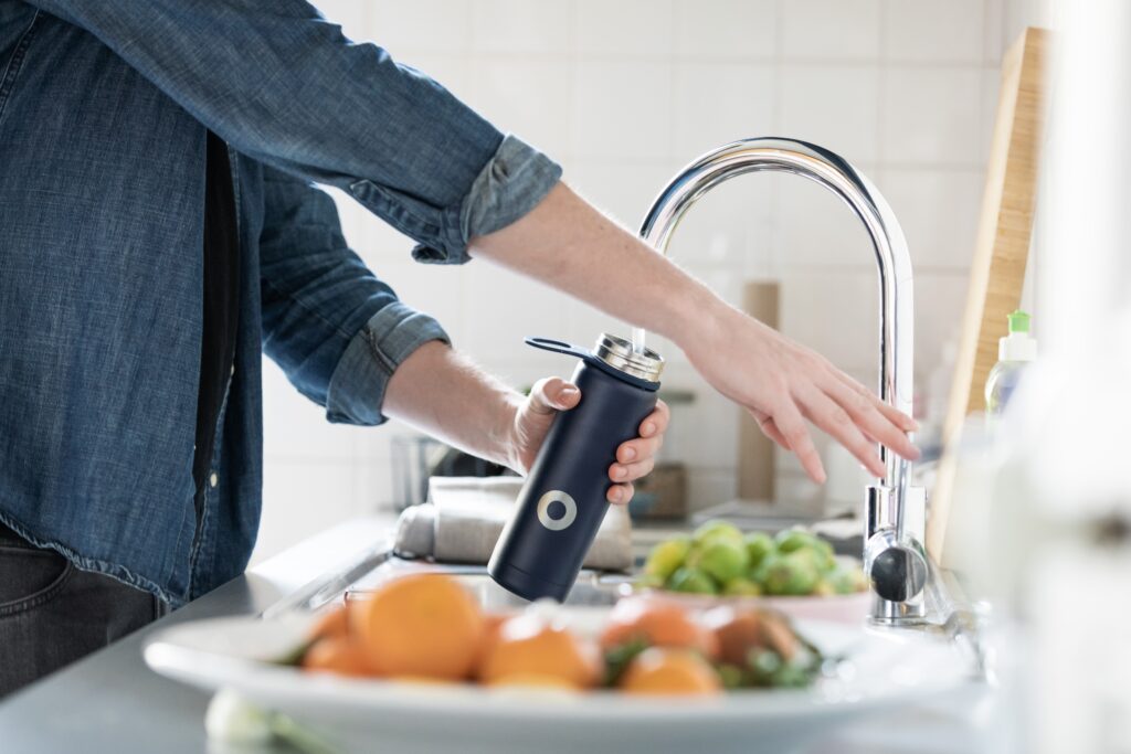 Image of a person filling up a water bottle showcasing one of the natural remedies for diabetes. A functional medicine doctor would suggest increasing your water intake in order to decrease insulin resistance.