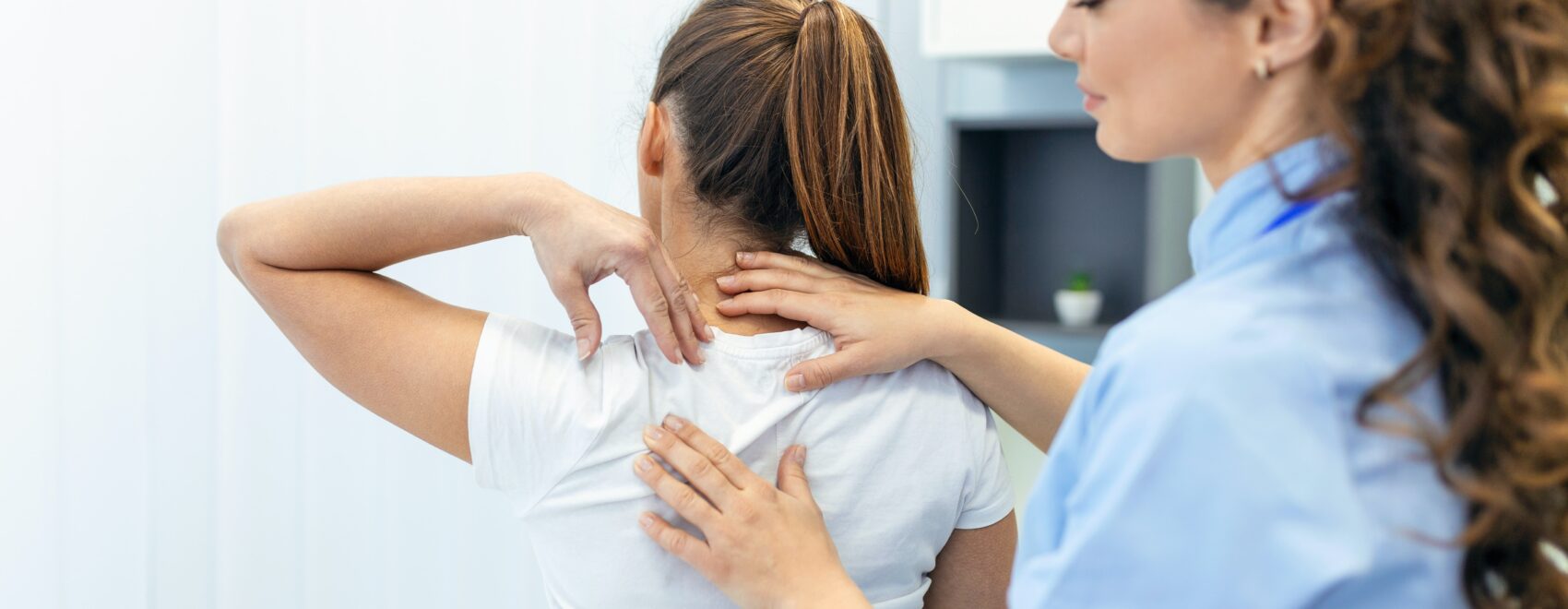Image of a Chiropractor in Orland Park assessing a patients back. Showing what you can expect when you can expect from seeing a holistic chiropractor for chiropractic care in Orland Park or the Chicago area.