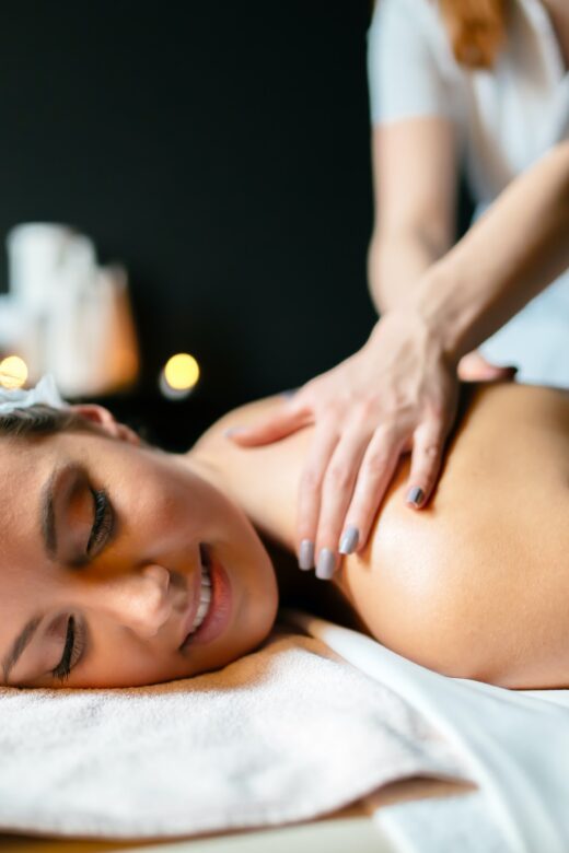 Image of a woman smiling while with a massage therapist. Representing what you can expect from getting a lymphatic drainage massage in Orland Park or the Chicago area.