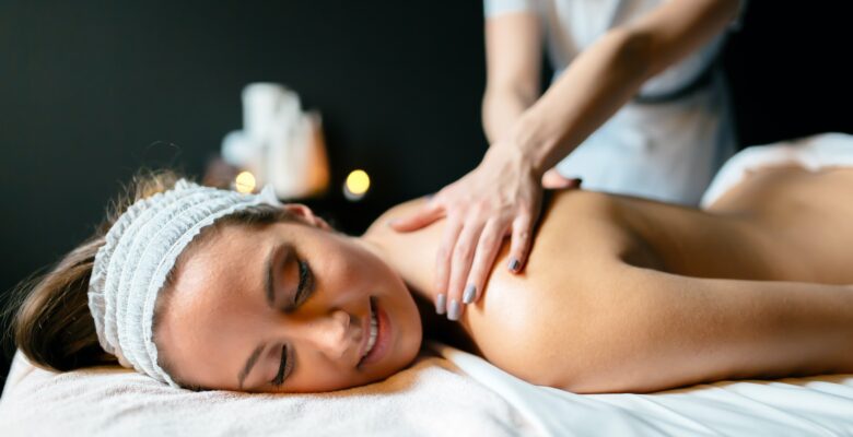 Image of a woman smiling while with a massage therapist. Representing what you can expect from getting a lymphatic drainage massage in Orland Park or the Chicago area.