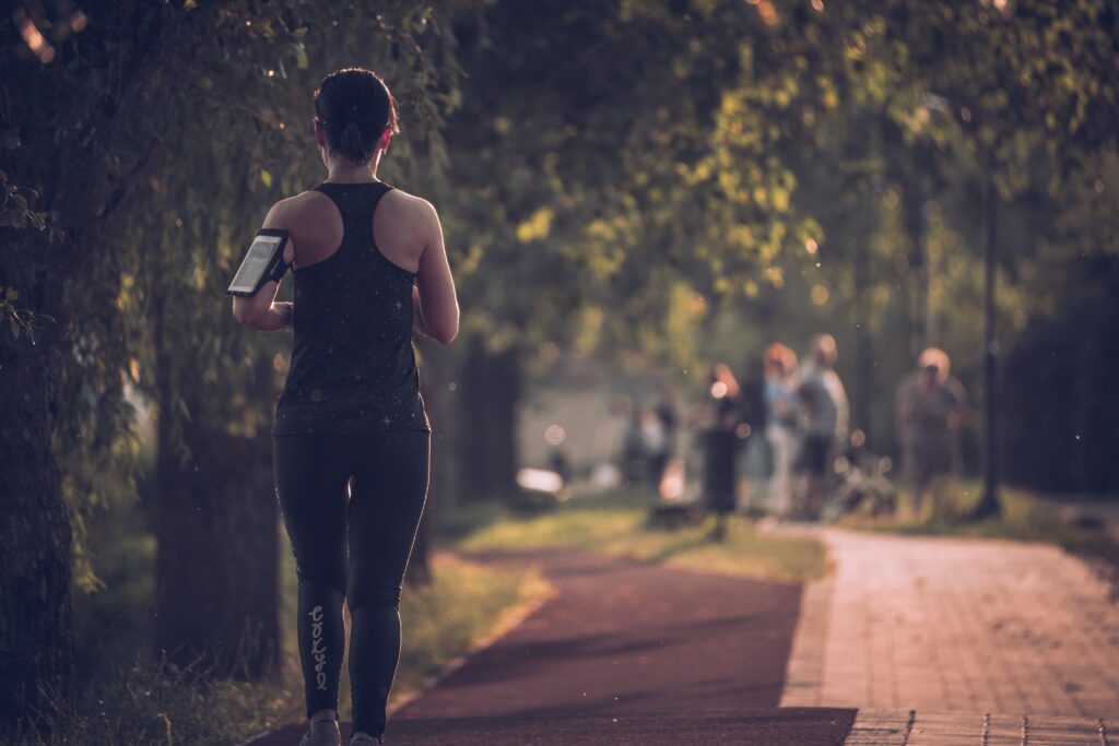 Image of a woman walking along a path in a park. Showing how good you can feel with chiropractic care in Orland Park, IL. With support from a holistic chiropractor in the Chicago area, you can feel more active.