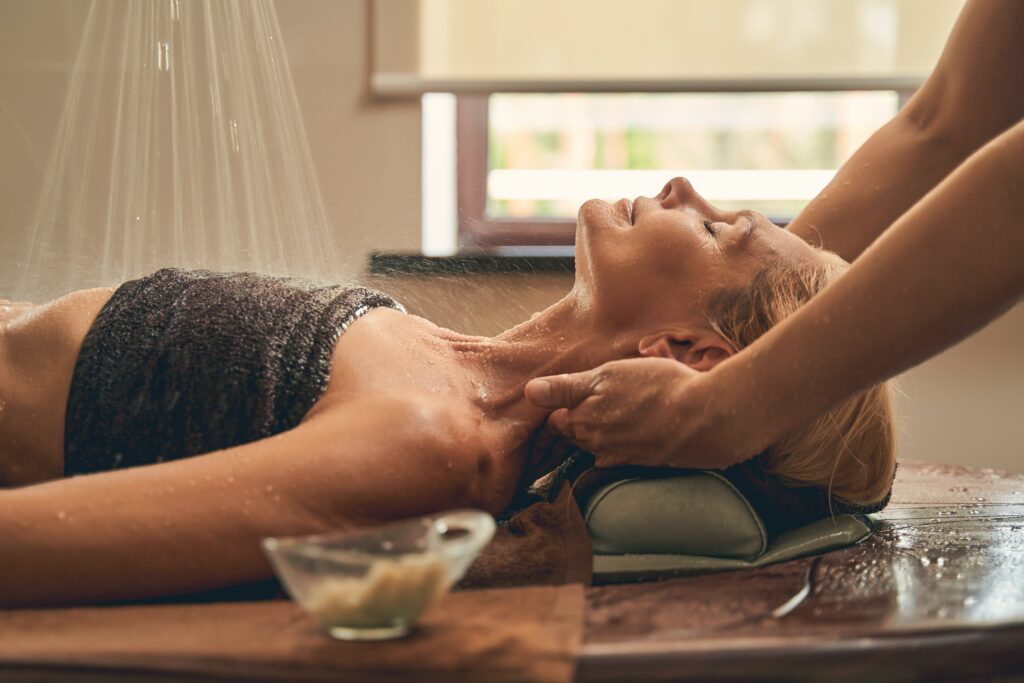 Image of a woman laying on a table getting a lymphatic drainage massage. Representing what you can expect when meeting with a massage therapist in Orland Park. Wherever you are in the Chicago area you can benefit from massage therapy.