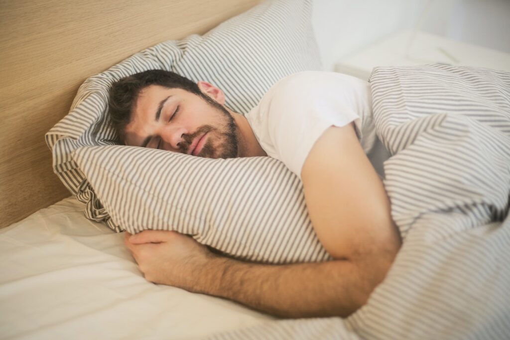 A man sleeps in bed, representing the sleep and wake cycles that a functional medicine doctor in the Chicago area can help you fix. Learn more about functional medicine in Orland Park, IL by searching “what is functional medicine Chicago area” today.
