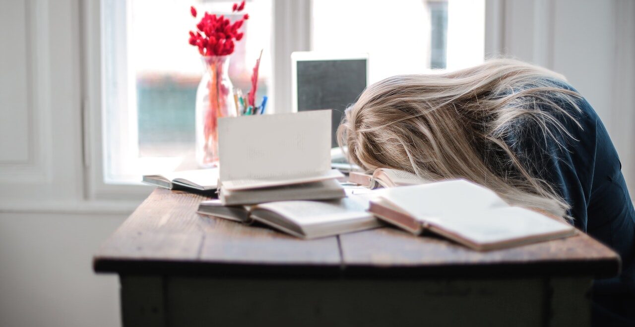 Shows someone tired laying on a desk. Represents how working with a functional medicine doctor in orland park, il can support you.