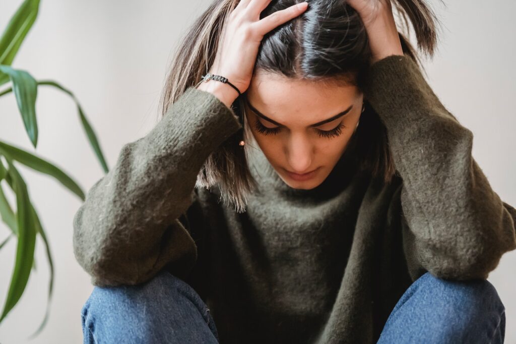 A woman holds her head while hanging her head. Learn how a functional medicine doctor in Orland Park, IL can offer support for overcoming fatigue. Contact a functional medicine doctor in the Chicago area or search “what is functional medicine Chicago area” today.
