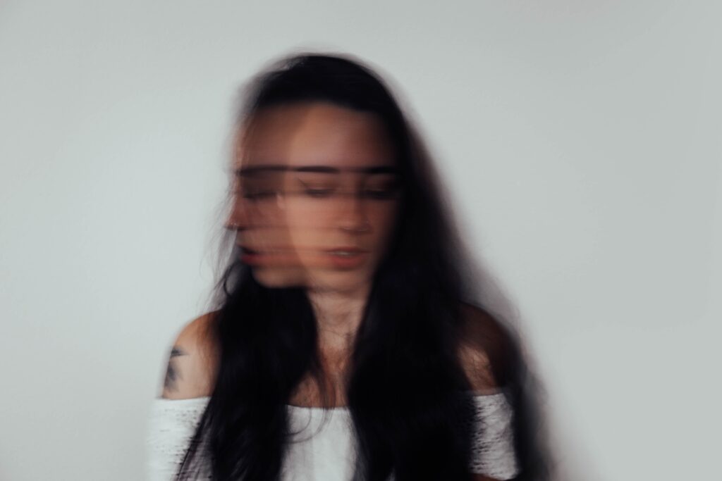 A woman stands as her head moves in a blur. Learn how a functional medicine doctor in Orland Park, IL can help you address hyperthyroid symptoms. Learn more about hormone imbalance Orland Park, IL, and the support a holistic doctor in Orland Park, IL can provide. 
