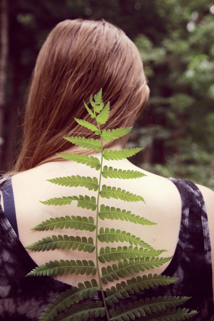 A woman stands with a plant on her back representing her spine. Learn how a holistic chiropractor in the Chicago area can offer support with chiropractic care in Orland Park, IL. Search for chiropractic care for sciatica in Orland Park, IL today. 
