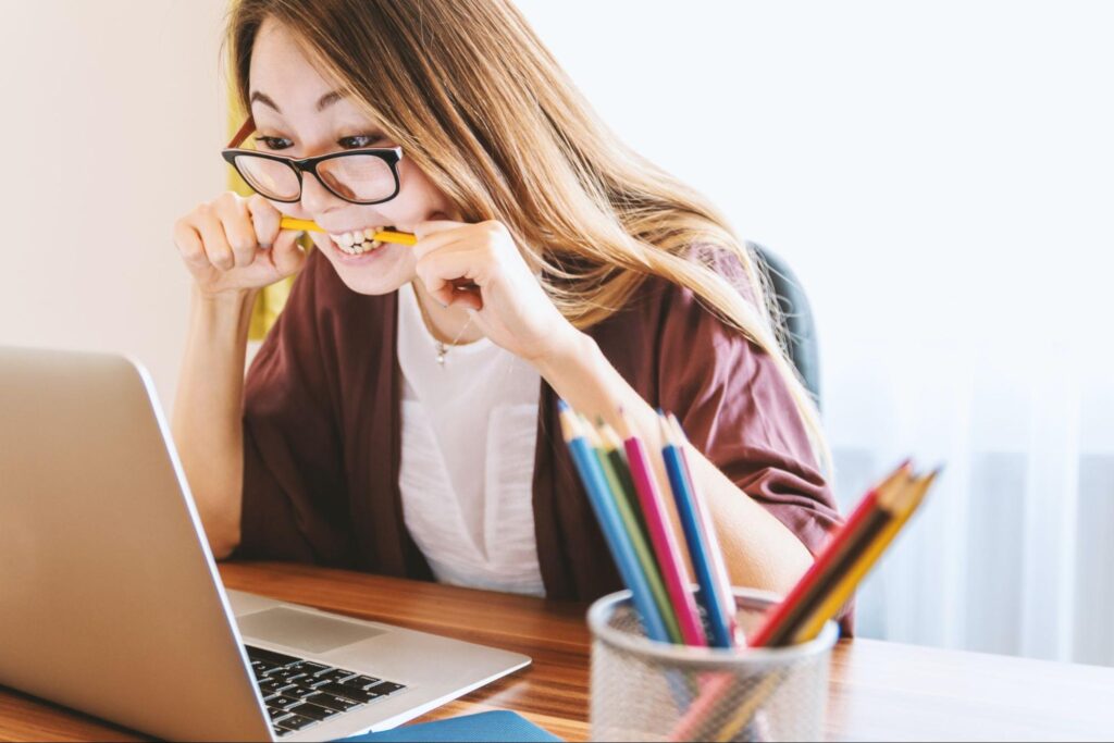 A woman bites a pencil while looking at her laptop. Learn how functional medicine in Orland Park, IL can offer support with overcoming stress by contacting a functional medicine doctor in the Chicago Area today.
