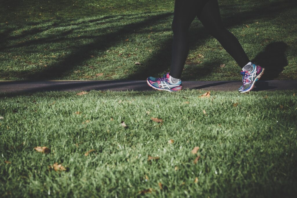 A close up of a person walking along a sidewalk. Learn how exercise can help improve mental health by contacting a holistic doctor in Orland Park, IL. They can offer functional medicine in Orland Park, IL, and other services. 
