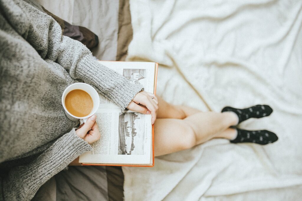 A close up of a person reading a book while holding a coffee. This could represent reducing stress. Learn how functional medicine in Orland Park, IL can offer support with overcoming stress by contacting a functional medicine doctor in the Chicago Area today.
