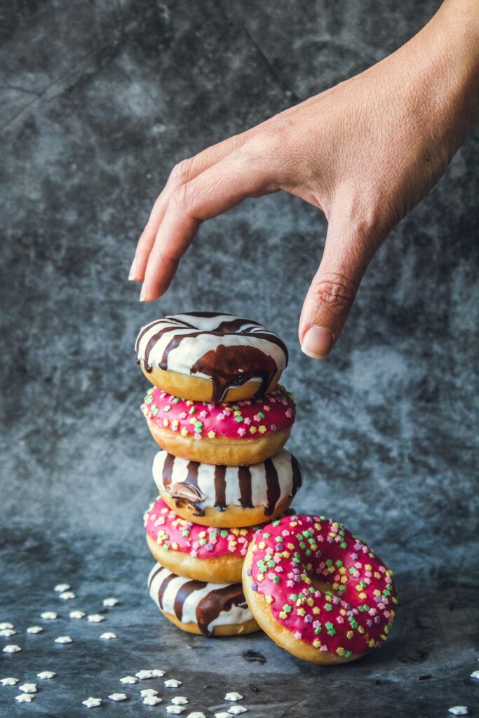 A hand reaches for a stack of doughnuts. Learn how a weight loss program in Orland Park, IL can offer support with addressing hormonal weight gain in Orland Park, IL by searching for a functional medicine doctor in Orland Park, IL today.
