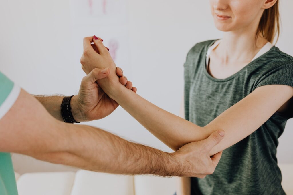 A close up of a doctor touching a patient's arm representing the support a holistic chiropractor in the Chicago area can offer. Learn more about kinesiology in Orland Park, IL and the support applied kinesiology in Orland Park, IL can offer. 
