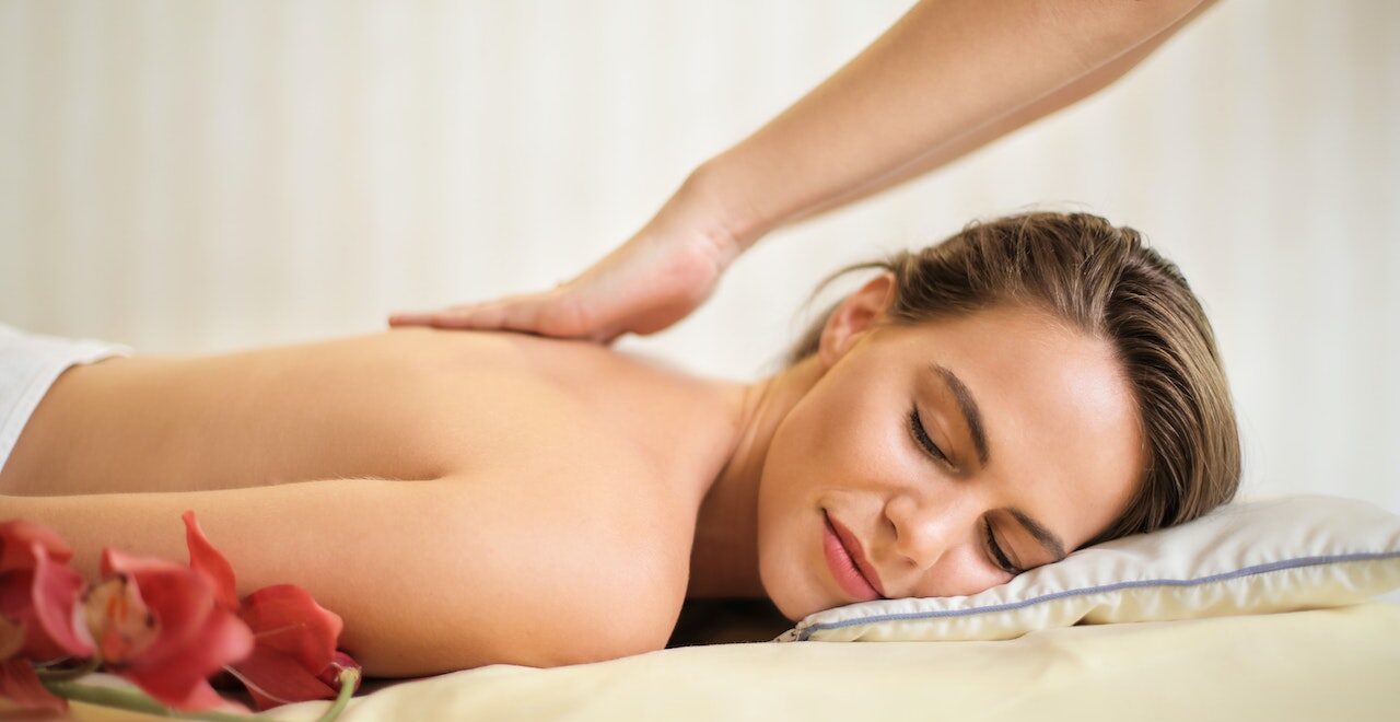 A woman lays down smiling while receiving a back massage. This could represent the benefits of massage therapy in Orland Park, IL for chronic pain. Learn more about the support a therapeutic massage in Orland Park, IL can offer today.