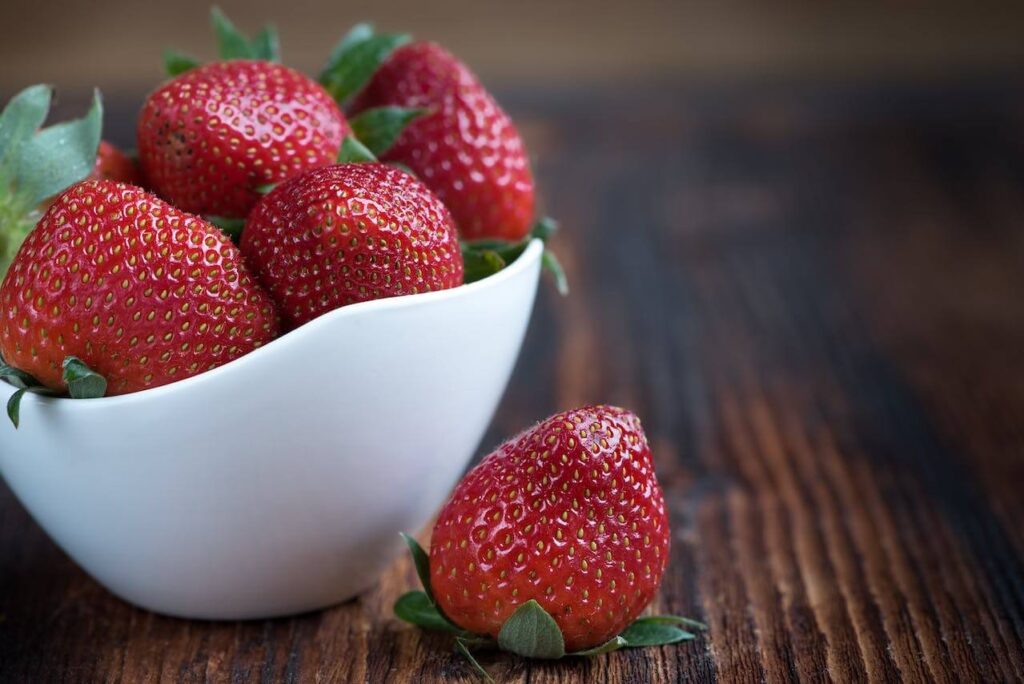 A close up of strawberries in a bowl with vitamins for an adrenal fatigue diet. Learn more about functional medicine in Orland Park, IL and the help a functional medicine doctor in the Chicago area. Search for hormone imbalance Orland Park, IL for support.
