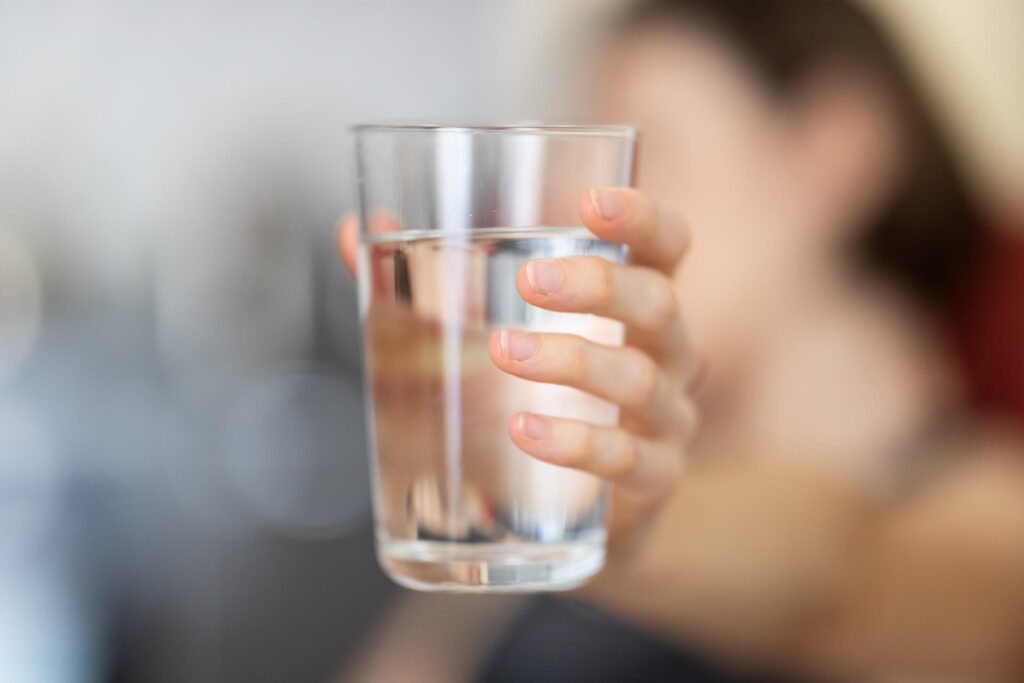 A close up of a person holding a water cup represents a fix for constipation. Learn more about a functional medicine doctor in the Chicago area by searching for detoxification in Orland Park, IL. 
