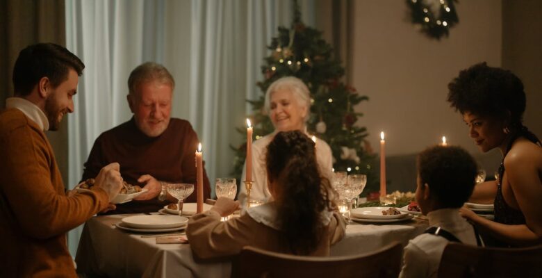 A family smiles while sitting around a dinner table. This could represent bonding during the holidays. Learn how a holistic doctor in Orland Park, IL can offer support with genetic health testing in the Chicago area and more.