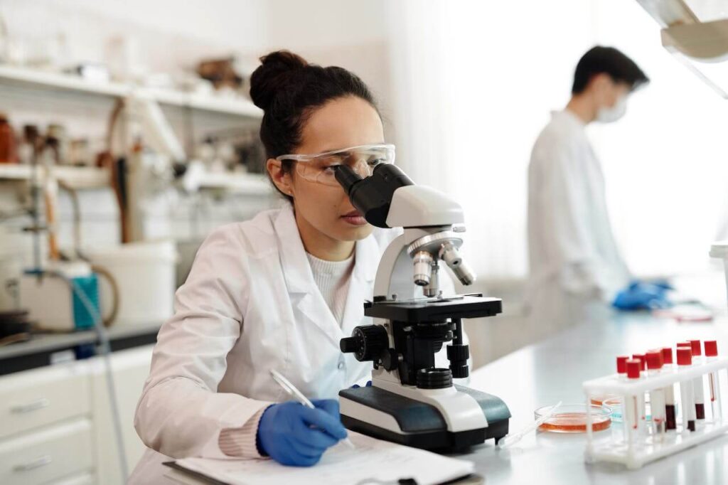 A  doctor looks through a microscope in a lab. Search for a functional medicine doctor in Orland Park, IL to learn more about what is functional medicine Chicago area and start genetic health testing in the Chicago area.
