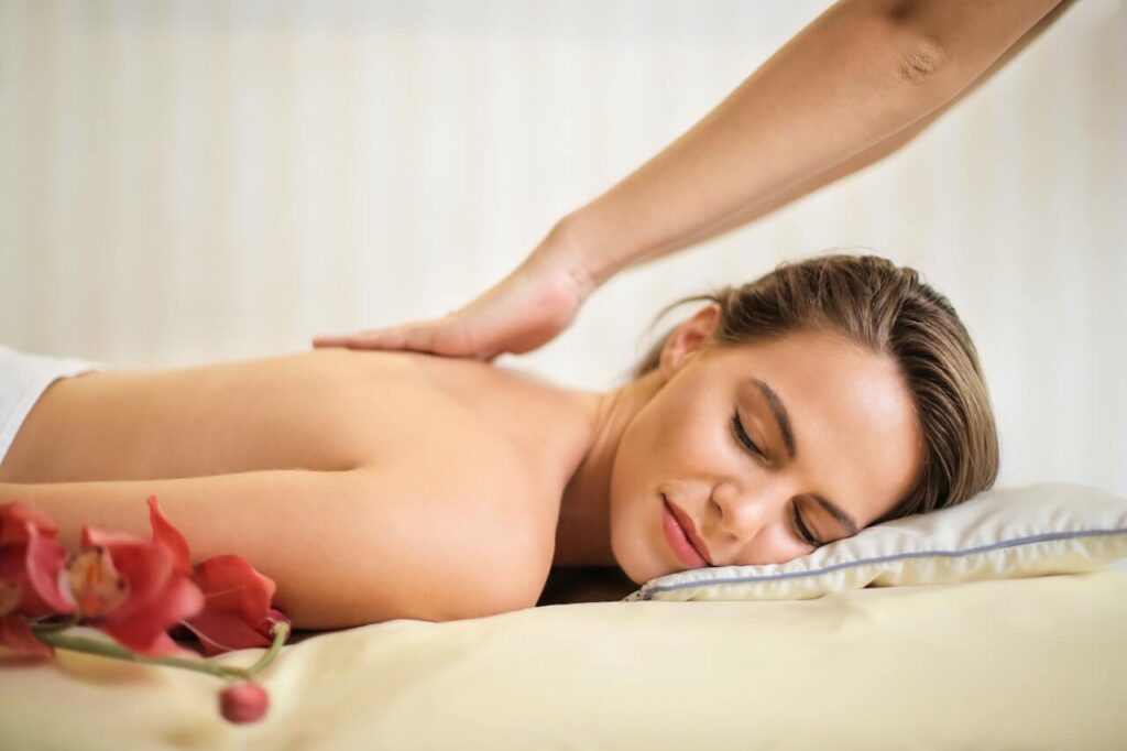 A close up of a woman smiling while laying down and getting a back massage. Learn how a massage therapist in Orland Park, IL can offer support with a lymphatic drainage massage in Orland Park, IL. Search for a holistic doctor in Orland Park, IL today for support or "therapeutic massage near me" today.
