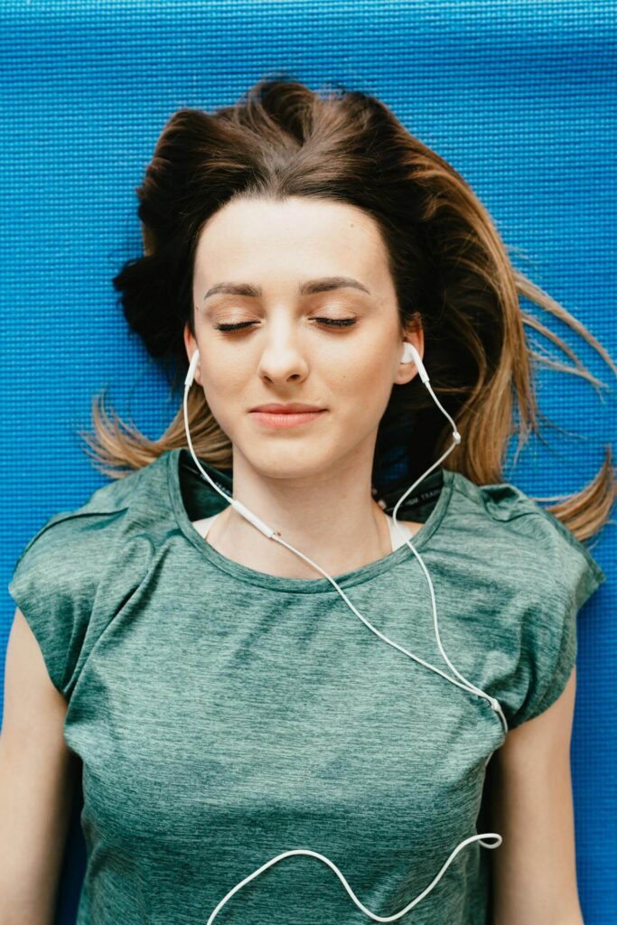 A woman lays on her back while listening to music through earbuds. Learn how stress relief can help address blood sugar irregularities by contacting a holistic doctor in Orland Park, IL. Contact a functional medicine doctor in Orland Park, IL to learn more. 
