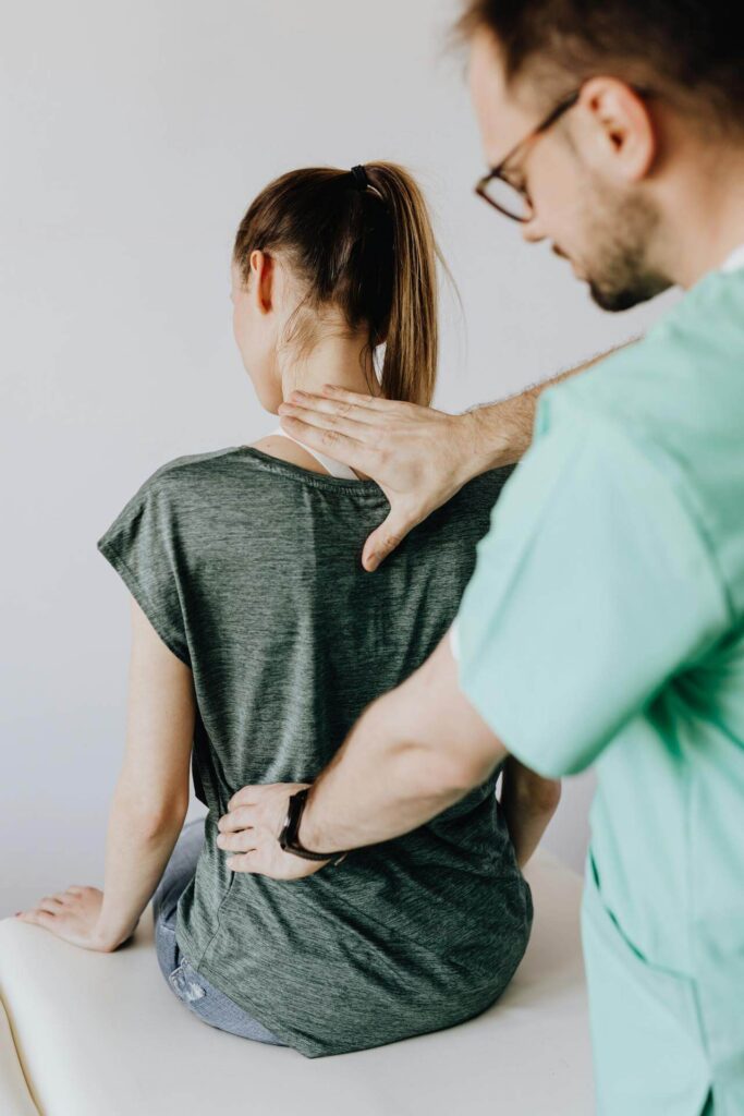 A doctor feels the back of a client with back pain. This could represent the help a holistic chiropractor in the Chicago area can offer. Search for a holistic doctor in Orland Park, IL or chiropractic care in Orland park, IL can help. 
