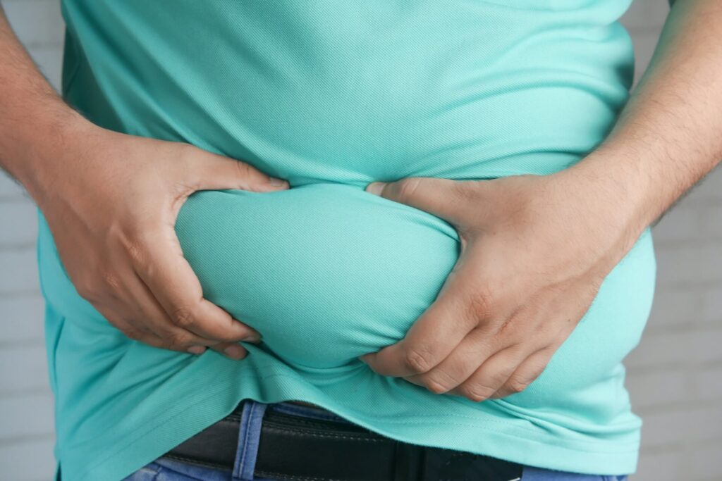 A close up of a person grabbing their stomach fat. Learn more about the effects of hormonal weight gain in Orland Park, IL and how diabetes functional medicine in Chicago, IL can help. Contact a holistic doctor in Orland Park, IL to learn more about Shape ReClaimed in the Chicago area. 
