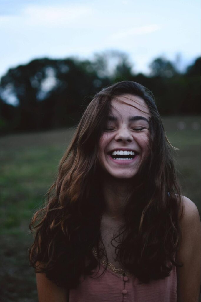 A woman laughs while standing in an open field. Learn how holistic medicine in the Chicago area can offer support with vagus nerve issues. Contact a holistic doctor in Orland Park, IL for more info on how a holistic massage in Orland Park, IL can help. 
