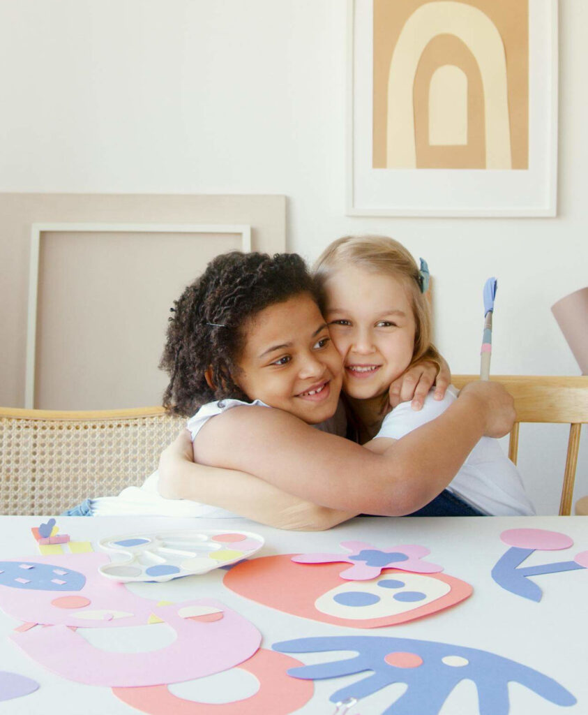 Two smiling children smile while hugging and painting on a table. Learn how about how a massage therapist in Orland Park, IL can offer support with massage therapy in Orland Park, IL and other services. Search for a therapeutic massage in Orland Park, IL to learn more.
