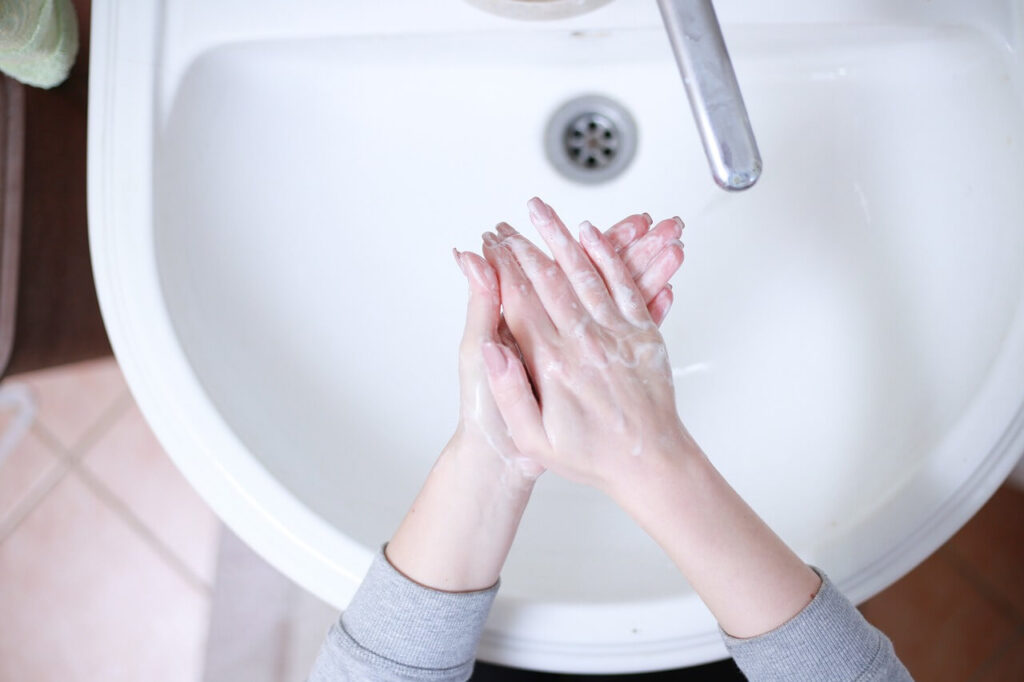 A top down view of a person scrubbing their hands in a kitchen sink. This could represent the benefits of hygiene for holistic health. Learn how a holistic chiropractor in the Chicago area can offer support with chiropractic care in Orland Park, IL and more. 
