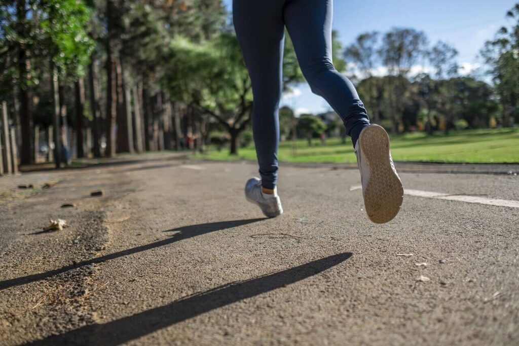 A close up of a person jogging on a sunny day. This could represent the benefits of exercise for holistic health. Learn how a holistic chiropractor in the Chicago area can offer support with chiropractic care in Orland Park, IL and more. 
