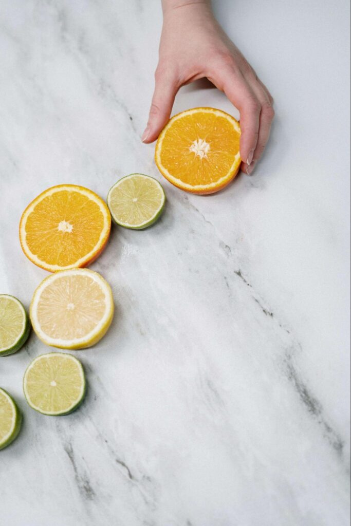 A close up of a hand placing lemons and lime slices on a table. This could represent holistic foods to boost immunity. Learn more from a holistic doctor in Orland Park, IL and learn more about how acupuncture in Orland Park, IL can help today.
