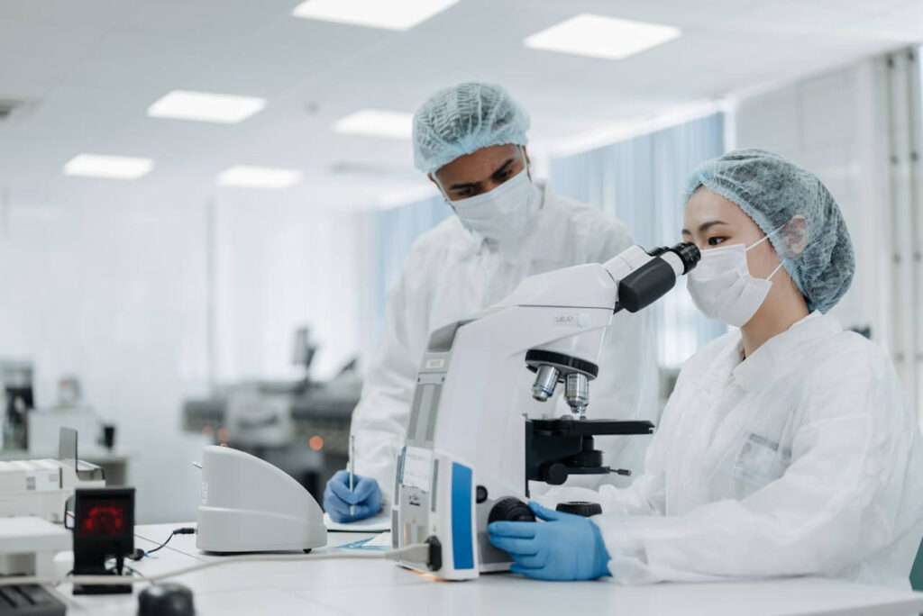 A doctor with a surgical cap and face mask sits at a table while looking through a microscope. This could represent the process of looking at genetic screening results. Learn how a holistic doctor in Orland Park, IL can help you understand the results of genetic health testing in the Chicago area today.
