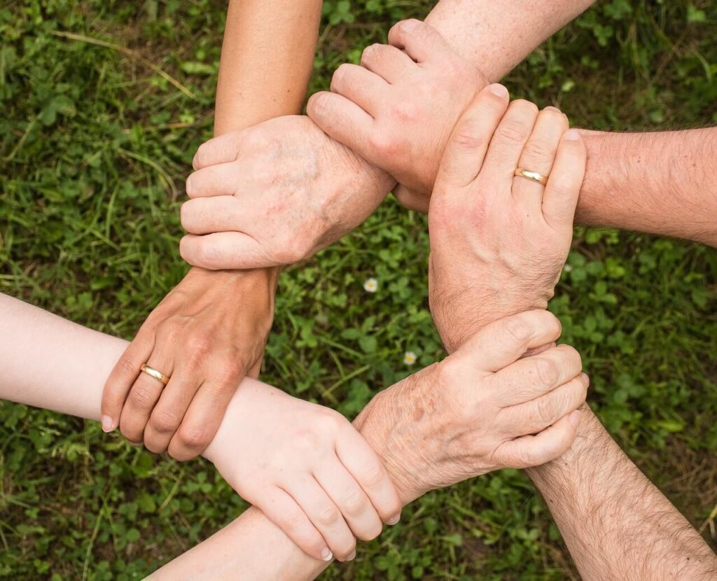 A diverse group of individuals is interlocking their hands in a circle against a grassy background, representing unity. Learn more about how social connections can help promote beneficial hormones. Contact a holistic doctor in Chicago, IL to learn more about how a therapeutic massage in Orland Park, IL can help. Search for massage chicago area today.
