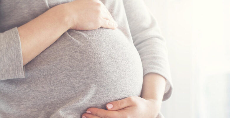 Shows a pregnant mother holding her stomach. Represents how a holistic doctor in chicago, il who is also a holistic chiropractor in the chicago area can help pregnant women like you to feel better during pregnancy.