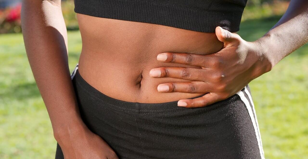 Shows a woman placing her hand on her stomach. Represents how a functional medicine doctor in the chicago area can support individuals with a leaky gut with holistic medicine in the chicago area.