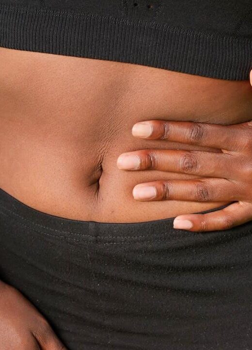Shows a woman placing her hand on her stomach. Represents how a functional medicine doctor in the chicago area can support individuals with a leaky gut with holistic medicine in the chicago area.