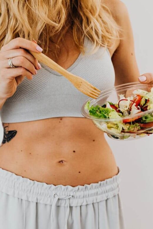 Shows a woman eating a salad with her stomach on display. Represents how a functional medicine doctor in orland park, il and gut health testing orland park, il can support gut health.