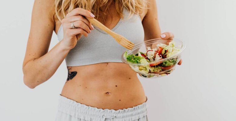 Shows a woman eating a salad with her stomach on display. Represents how a functional medicine doctor in orland park, il and gut health testing orland park, il can support gut health.