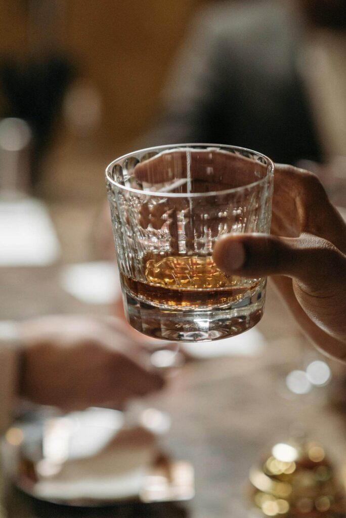 Man holding a glass of alcohol showing what a man puts in his body affects hormones like testosterone. Represents how you can use hormone testing in Orland Park, IL and functional medicine doctor in the chicago area can help your health.