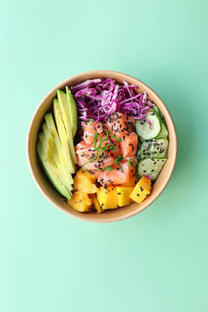 Salmon Bowl | functional medicine in orland park, il | holistic doctor in chicago, il | holistic medicine in the chicago area | functional medicine doctor in the chicago area | Preserve at Marley Creek, IL | River North, IL | Hyde Park, IL Shows a samon bowl in a bamboo bowl and a mint background. Represents how a functional medicine doctor in the chicago area would recommend this diet in functional medicine in orland park, il.