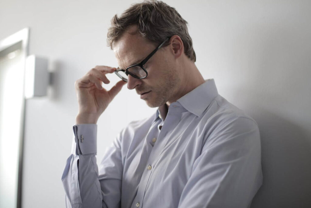 Shows a man looking down due to anxiety. Represents how chiropractic care in orland park, il and a holistic chiropractor in the chicago area can help alleviate anxiety.