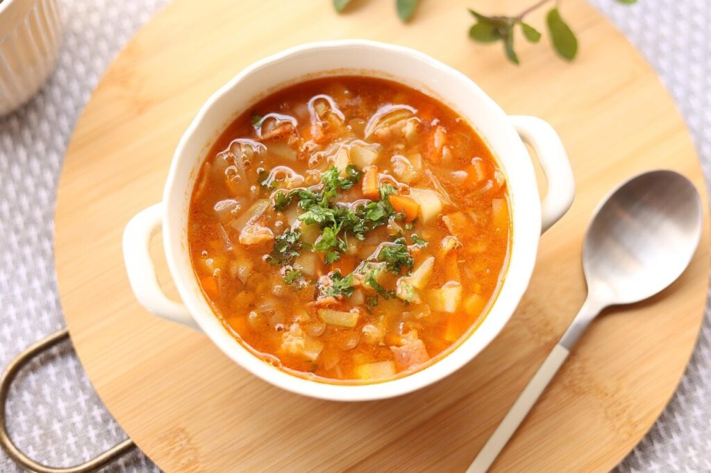 Shows a healthy bowl of chicken soup with a spoon. Represents how functional medicine in orland park, il prioritizes eating healthy foods when you're sick but can also talk to you about other methods like chiropractic in orland park, il.