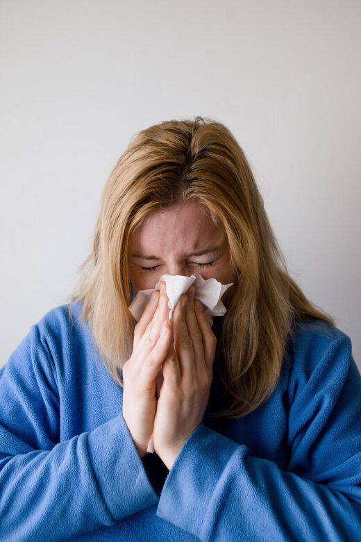 Woman blowing her nose. Represents how functional medicine in Orland Park, IL with a functional medicine doctor in Chicago, IL can help you prepare for cold and flu season.