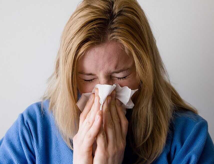 Woman blowing her nose. Represents how functional medicine in Orland Park, IL with a functional medicine doctor in Chicago, IL can help you prepare for cold and flu season.