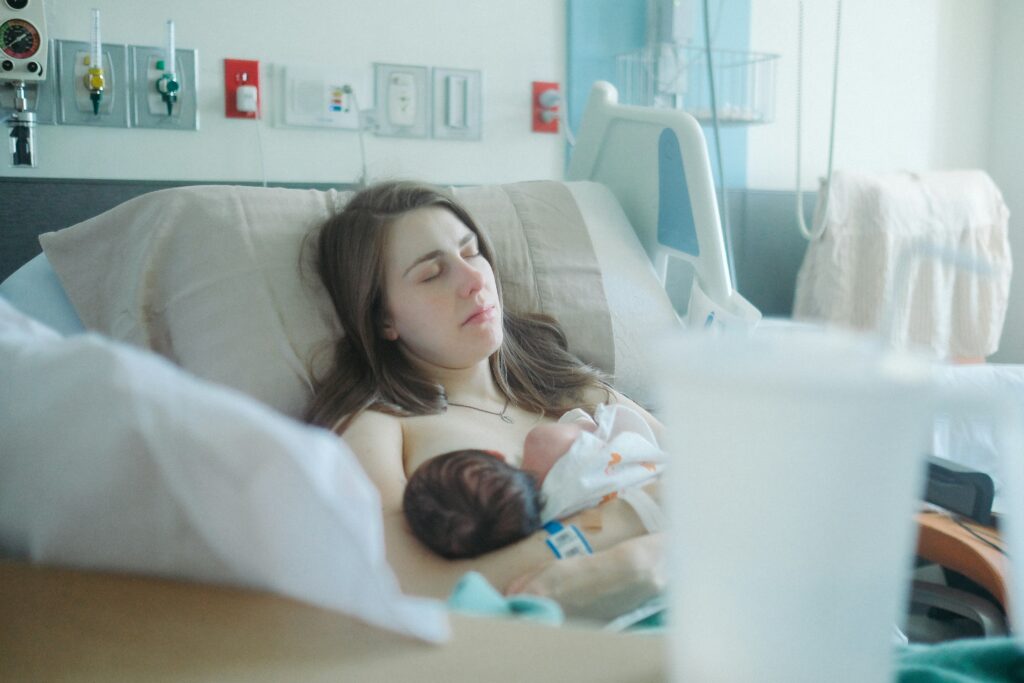Image of a mom soon after birth holding her baby. Have you recently had a baby and looking for "massage therapy near me"? If so you could benefit from getting a post natal massage in Orland Park, IL 60467. Reach out and schedule your postpartum massage at our Orland Park, IL office. Call today!