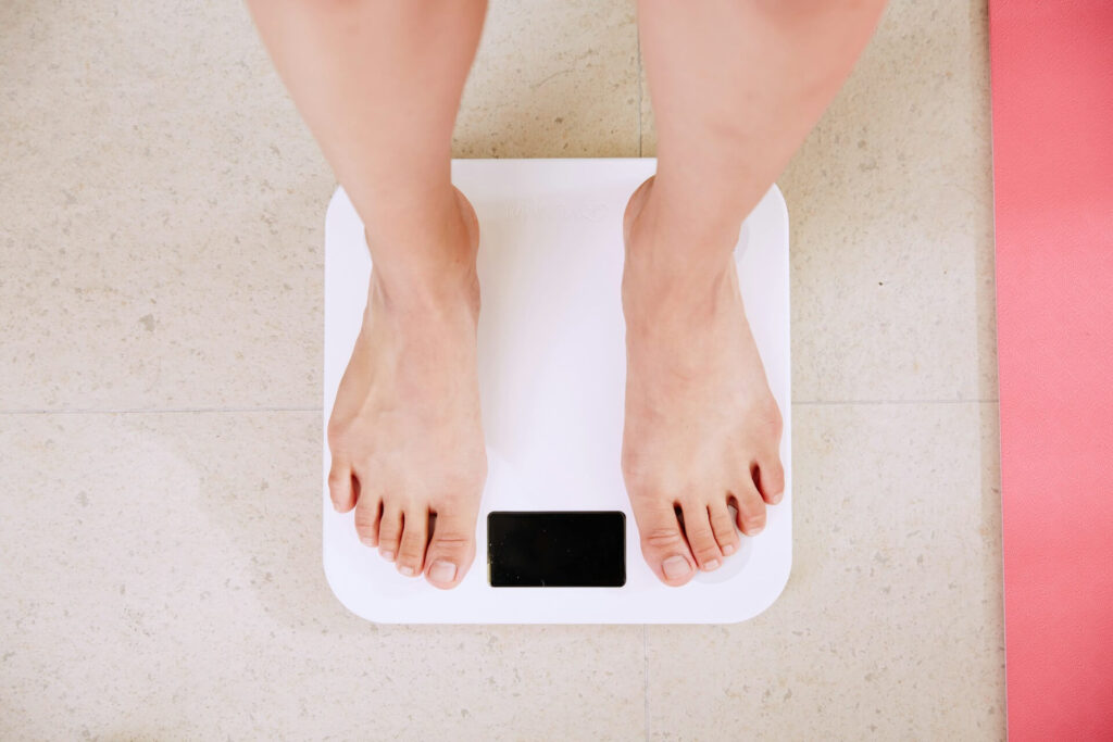 Feet on a white scale. Struggling with gaining weight in perimenopause? Find support from a functional medicine doctor in Orland Park, IL to take back control.