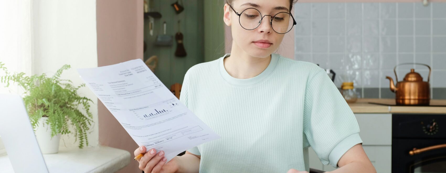 Young woman looking at bills and a Good Faith Estimate for medical care in Orland Park, IL.