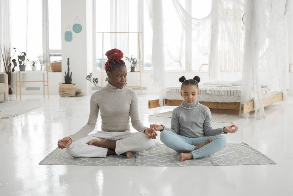 yoga | functional medicine for sleep | how to get a good night sleep | functional medicine | Mokena | Frankfort | Tinley Park Mom and daughter sitting on a rug practicing yoga poses. Functional medicine for sleep helps reset your child's sleep rhythms naturally for a smoother back-to-school transition in Orland Park, IL.