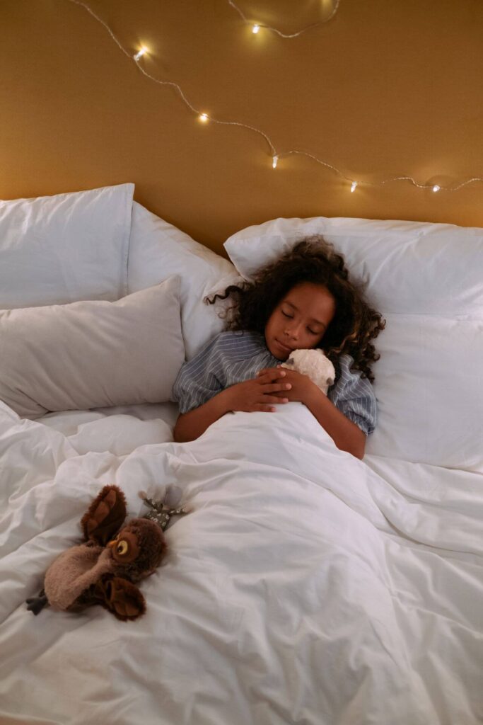 girl sleeping | what is functional medicine | functional medicine insomnia | sleep support | Homewood | Oak Lawn | Orland Park Peaceful little girl laying in bed snuggling with a plush toy. Wondering what is functional medicine? It's a root-cause approach to sleep support and whole-body health for your family in Orland Park, IL.